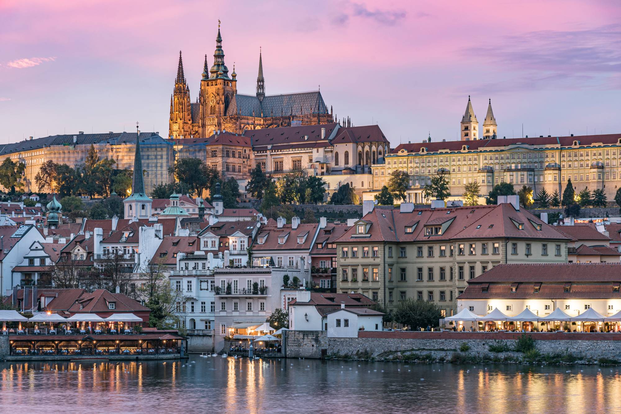 Pogled proti Hradčanom na levem bregu reke Vltave v Pragi z gotsko stolnico svetega Vida in praškim gradom.