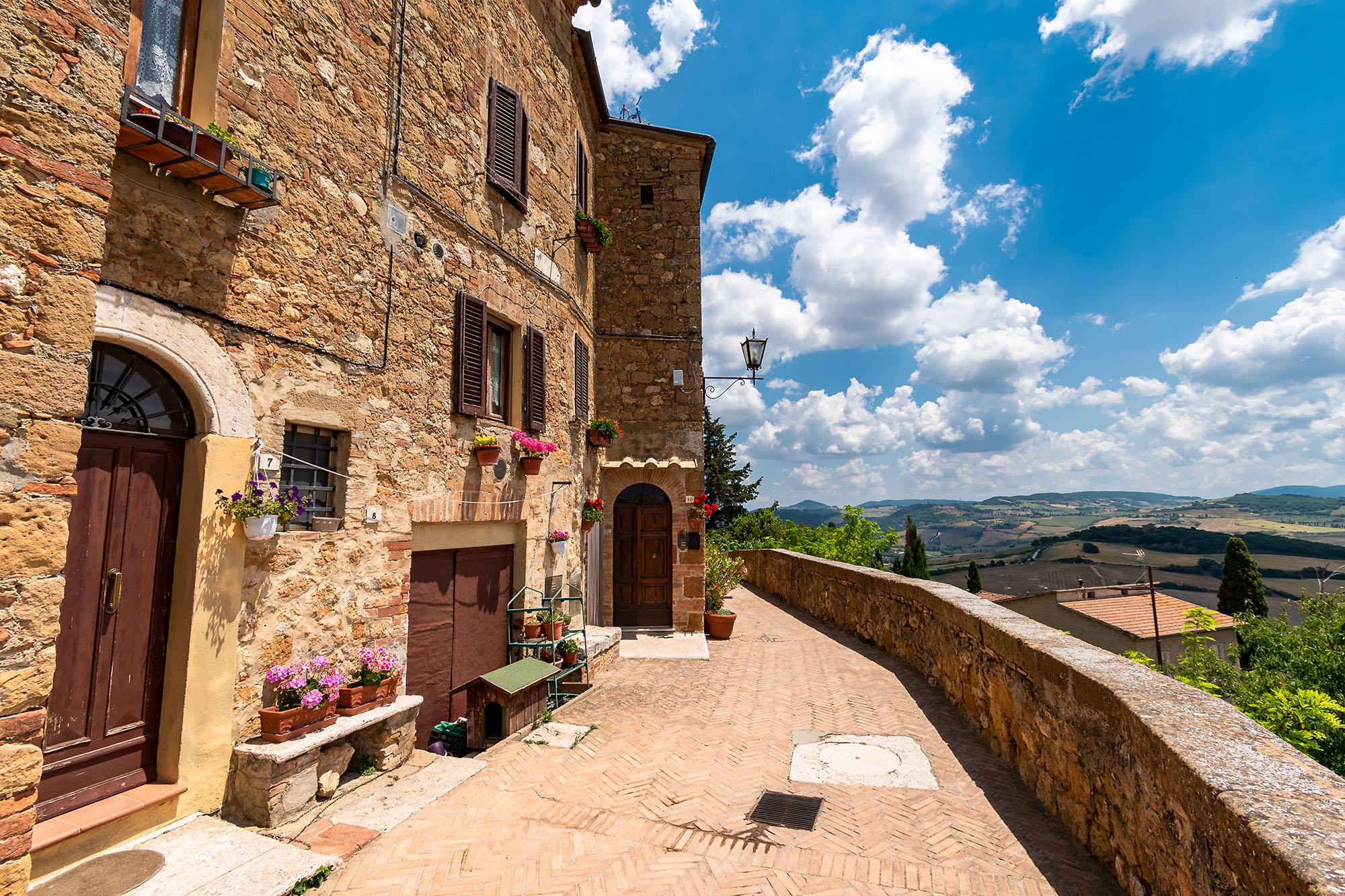 Hiše ob obzidju Pienze, od koder se odpira čudovit razgled na pokrajino v toskanski dolini Val d'Orcia.