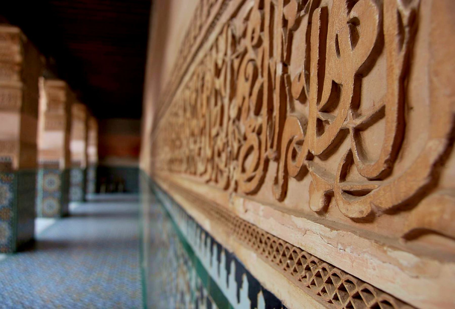 Detajl na steni medrese Ben Youssef v Fesu, v kamen vklesani citati iz Korana.