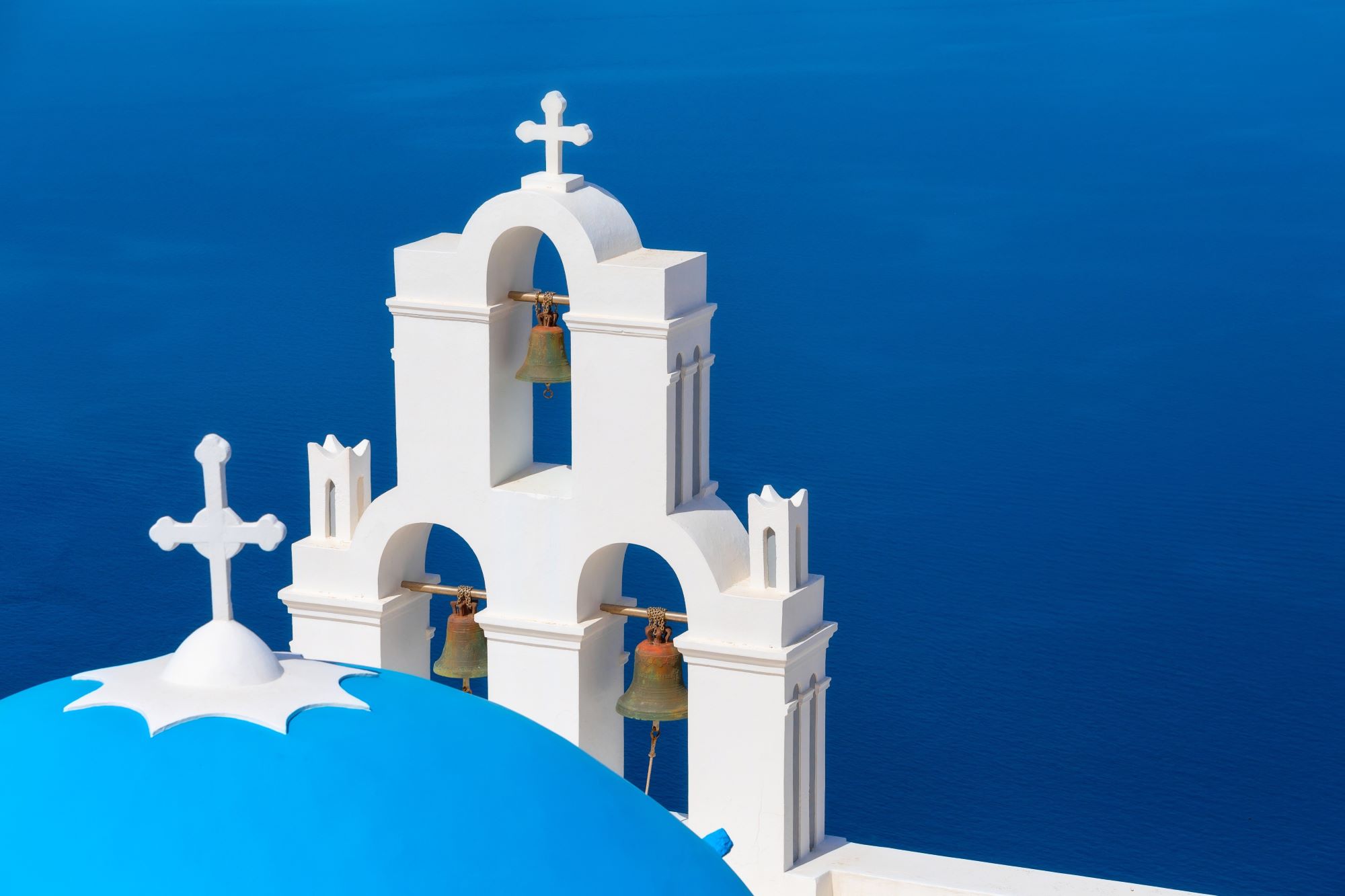 Bel zvonik in bela kupola cerkve na Santoriniju.