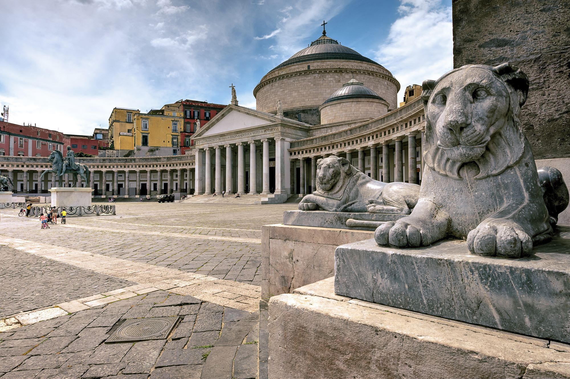 Pogled na kipa levov in trg Piazza del Plebiscito v starem delu Neaplja z baziliko San Francesco di Paola.