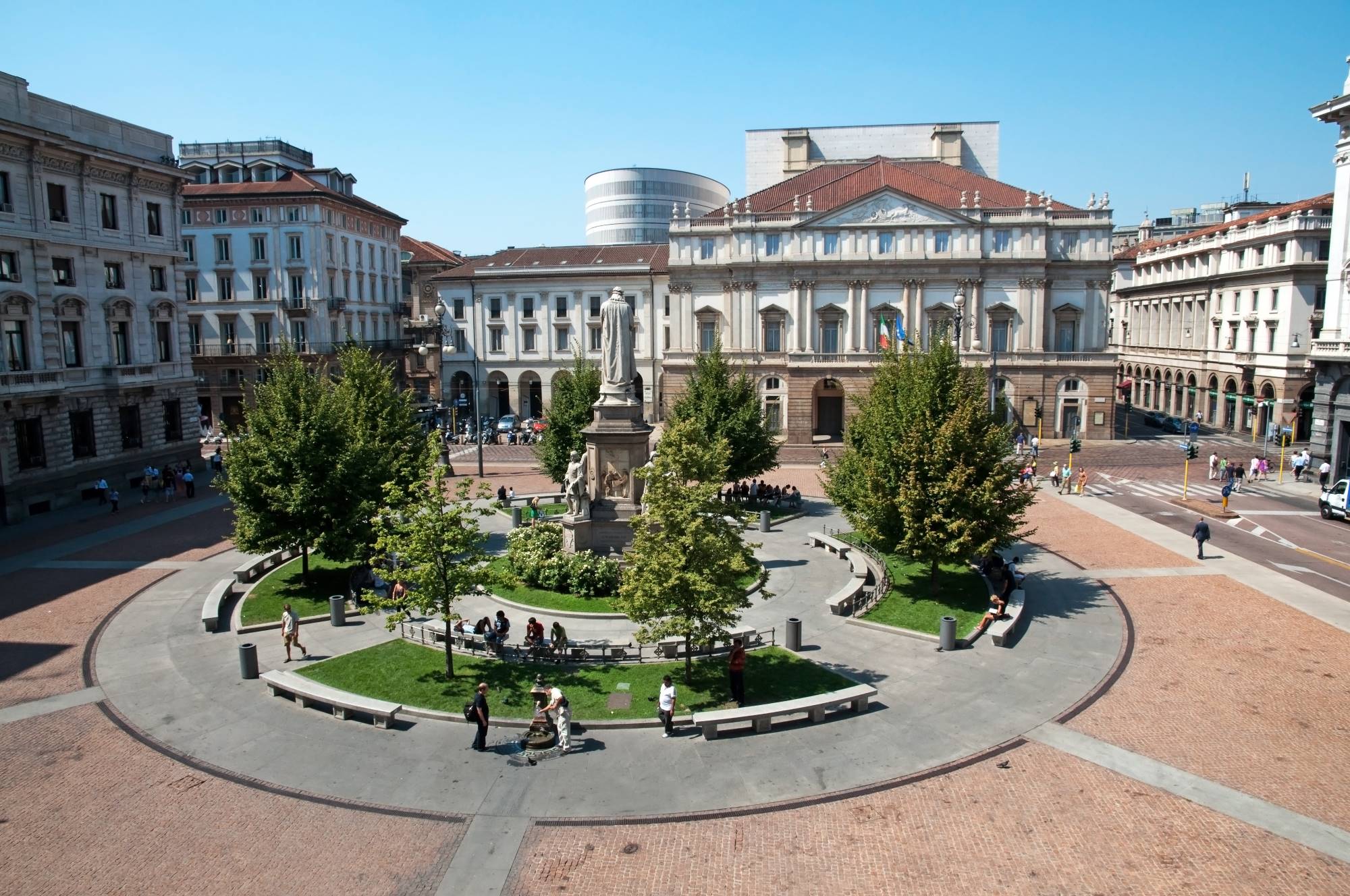 Trg Piazza della Scala v Milanu v Italiji z vodnjakom in v ozadju znamenita in ena najbolj znanih opernih hiš na svetu La Scala.