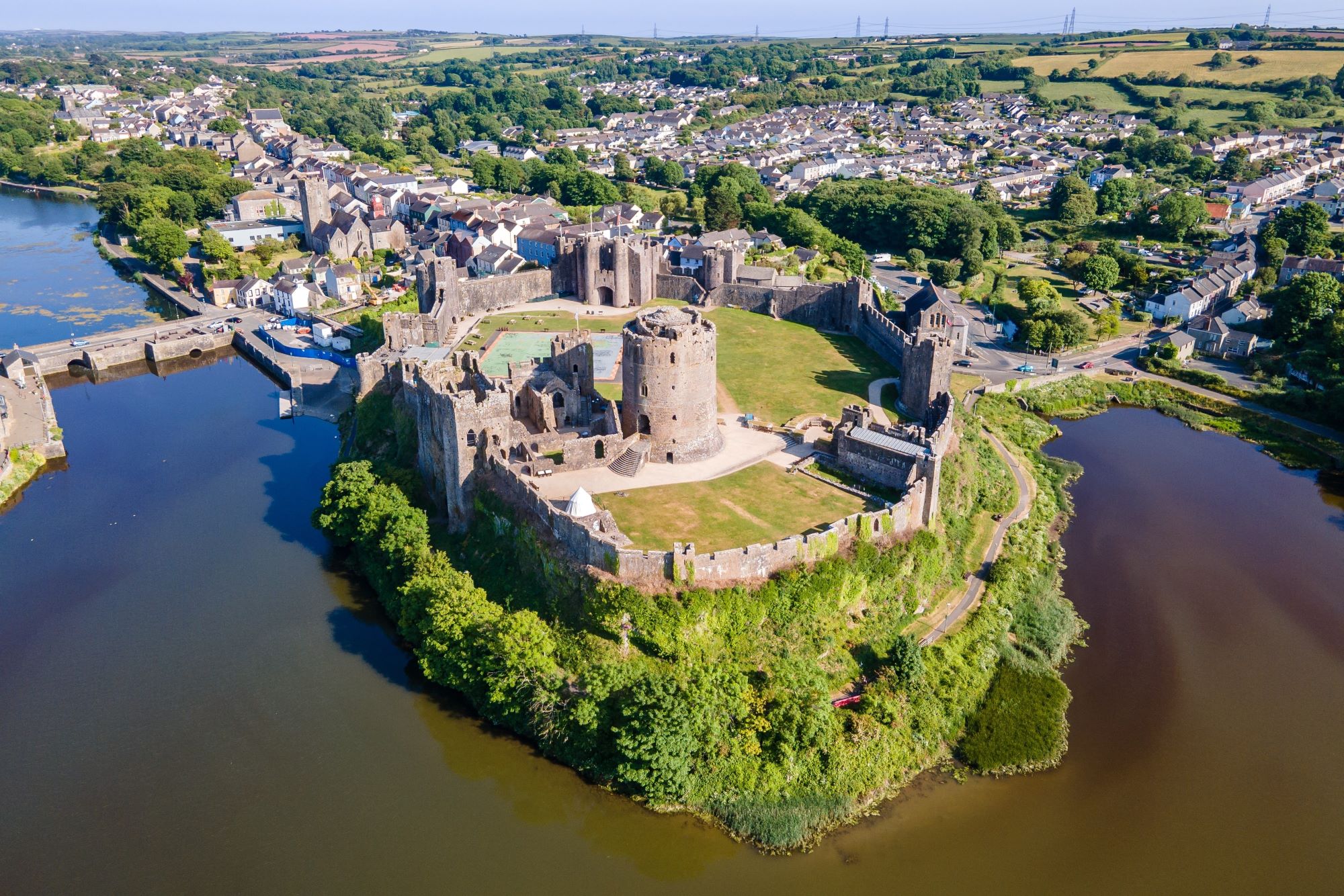 Zračni pogled na srednjeveški grad Pembroke na jezeru Mill v Walesu in v ozadju kraj Pembroke.