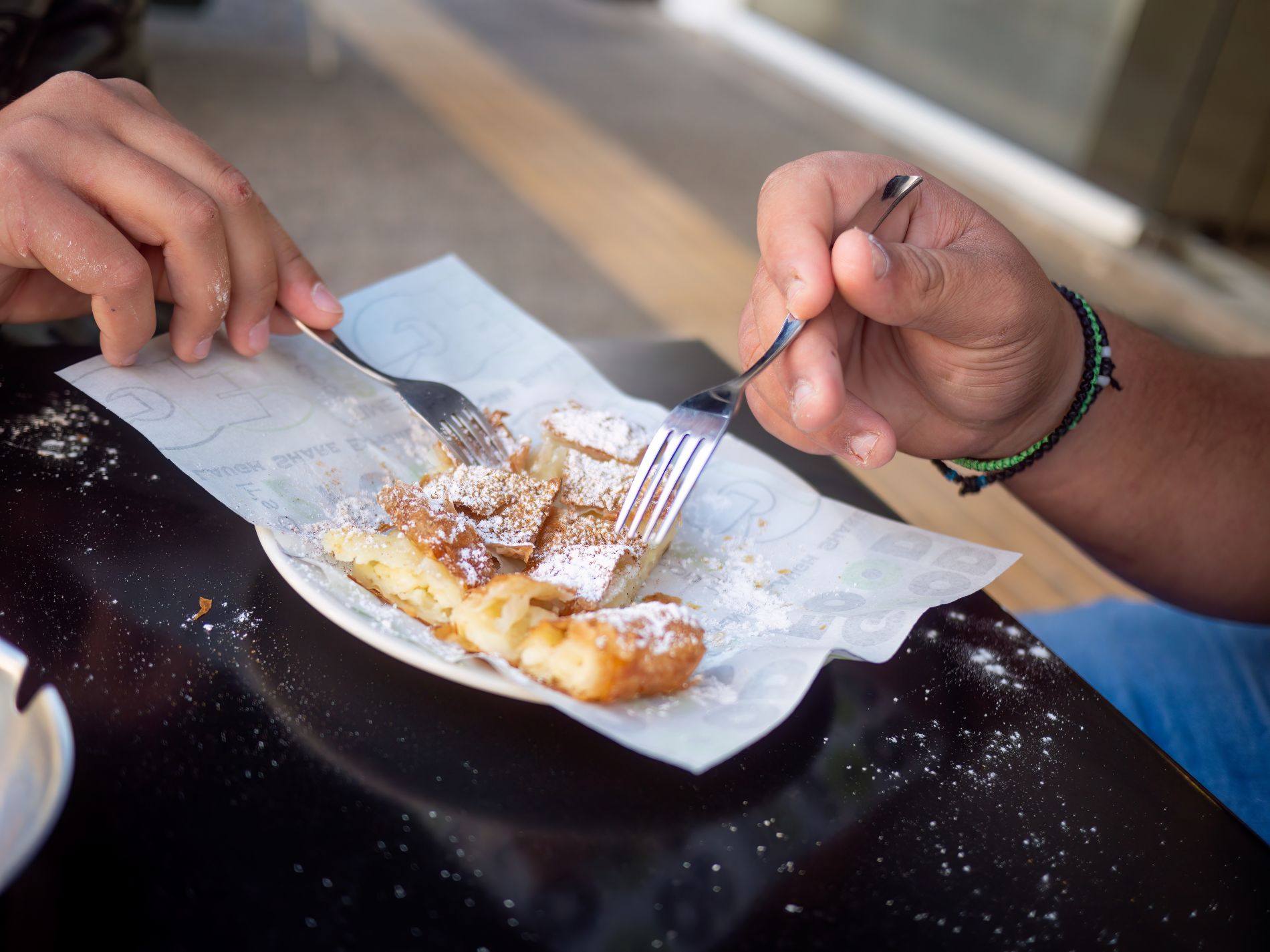 Grška sladica pita bougatsa, ki jo na ulici Soluna jesta dve osebi.