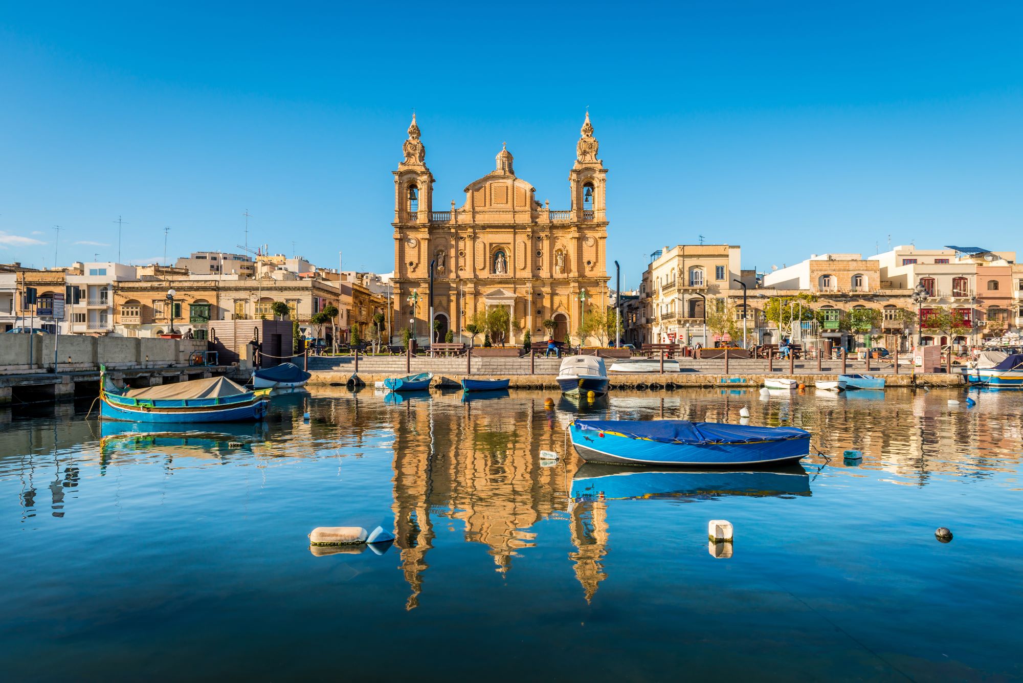 Zaliv z marino v kraju Msida na Malti in pogled na baročno cerkev svetega Jožefa.