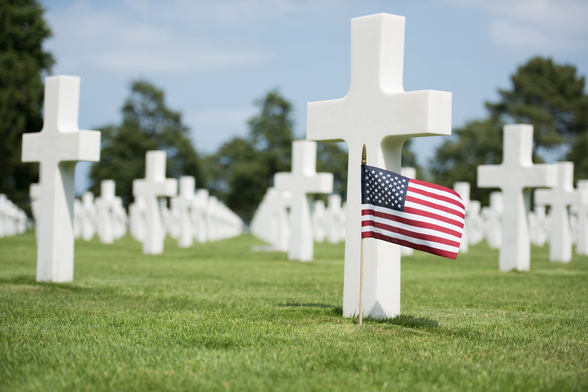 Križi in ameriška zastava na ameriškem pokopališču in spominskem obeležju nad obalo Omaha v Normandiji.
