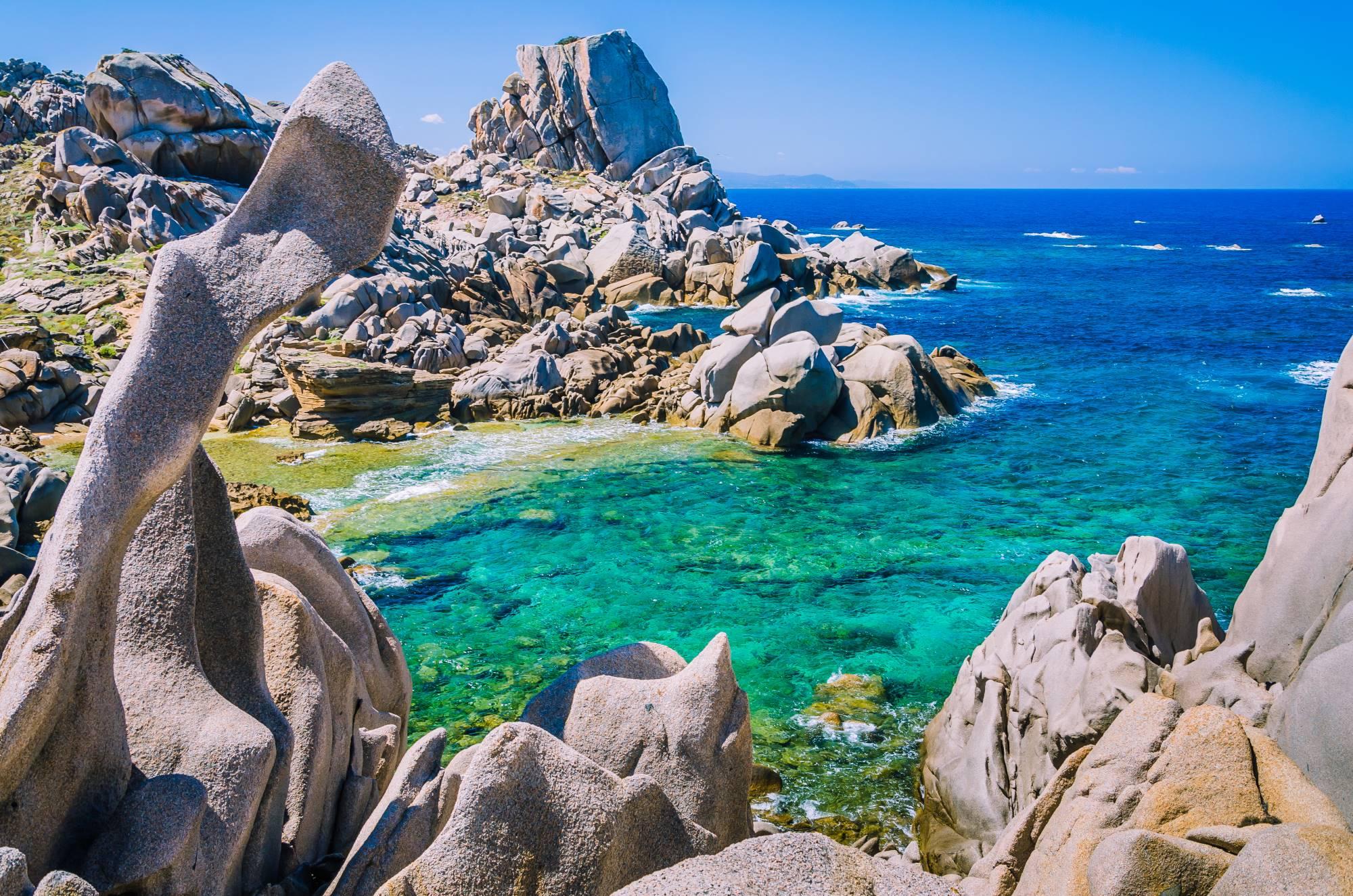 Slikoviti rt Capo Testa na Sardiniji z nenavadno oblikovanimi granitnimi skalami, iz katerih sta morje in veter izdolbla prave skulpture.