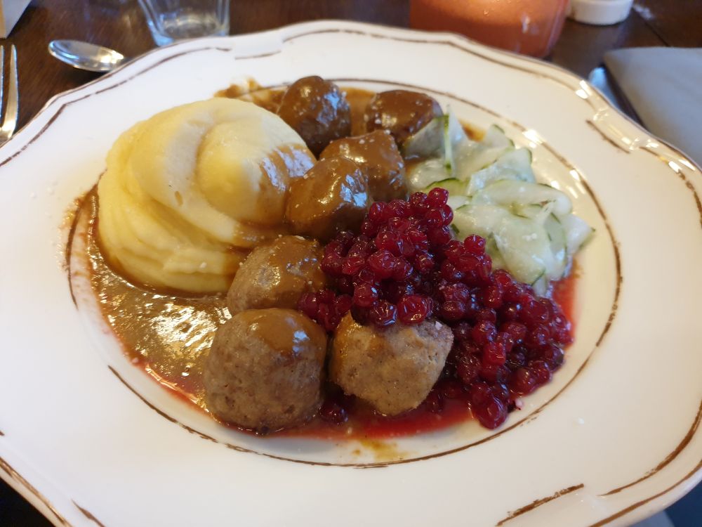 Mesne kroglice z brusnično omako in pire krompirjem.