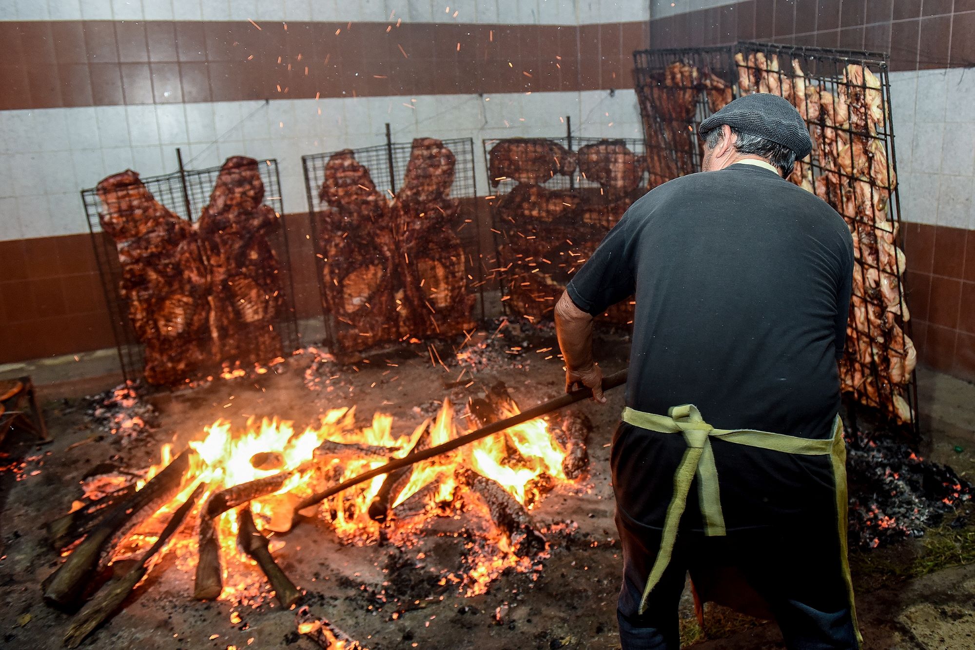 Južnoameriški kavboj gaučo iz Patagonije na jugu Argentine pripravlja žerjavico za peko mesa na žaru.