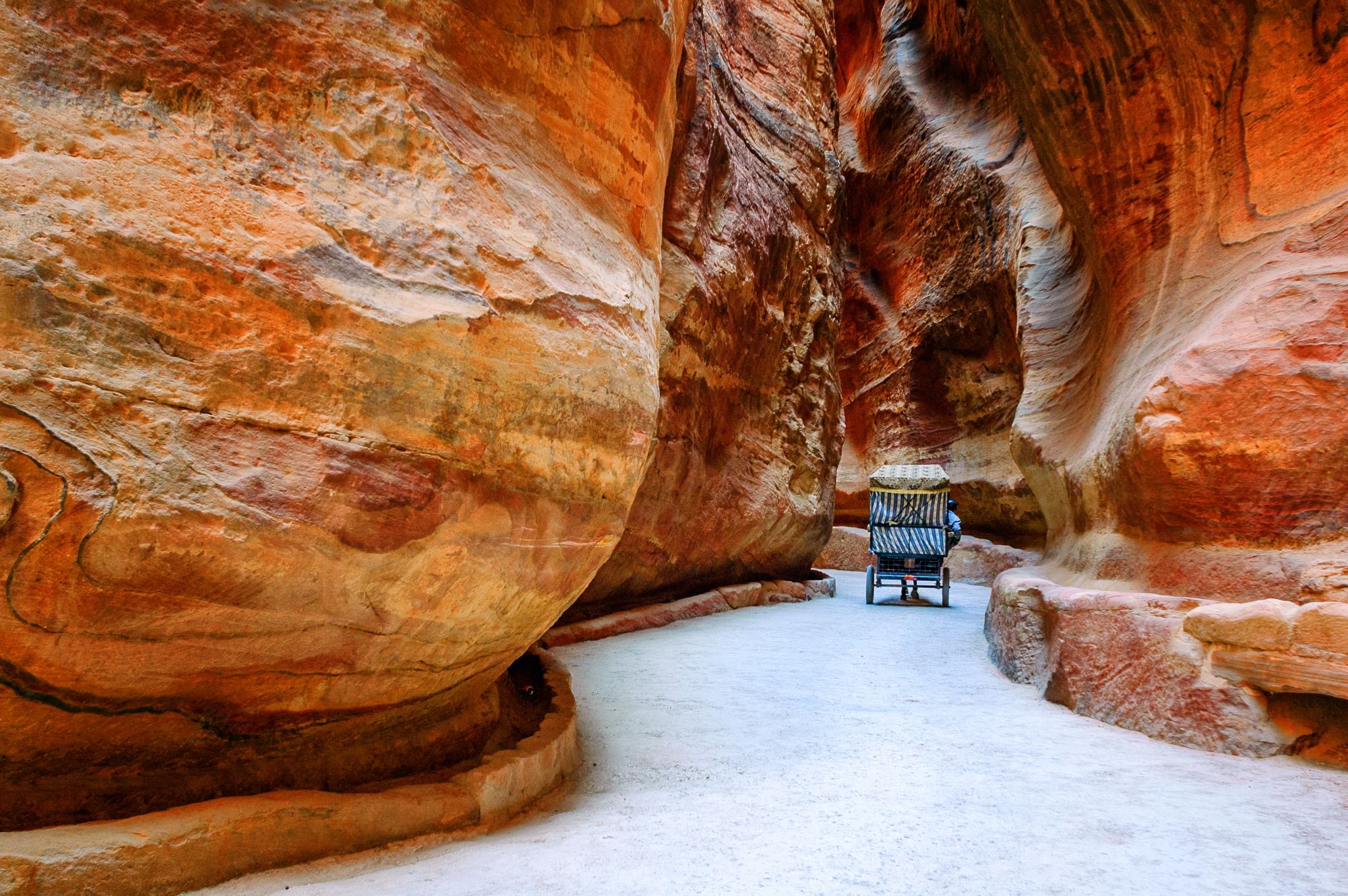 Konjska vprega skozi ozko sotesko ali sik pelje turiste v nabatejsko mesto Petra v Jordaniji.