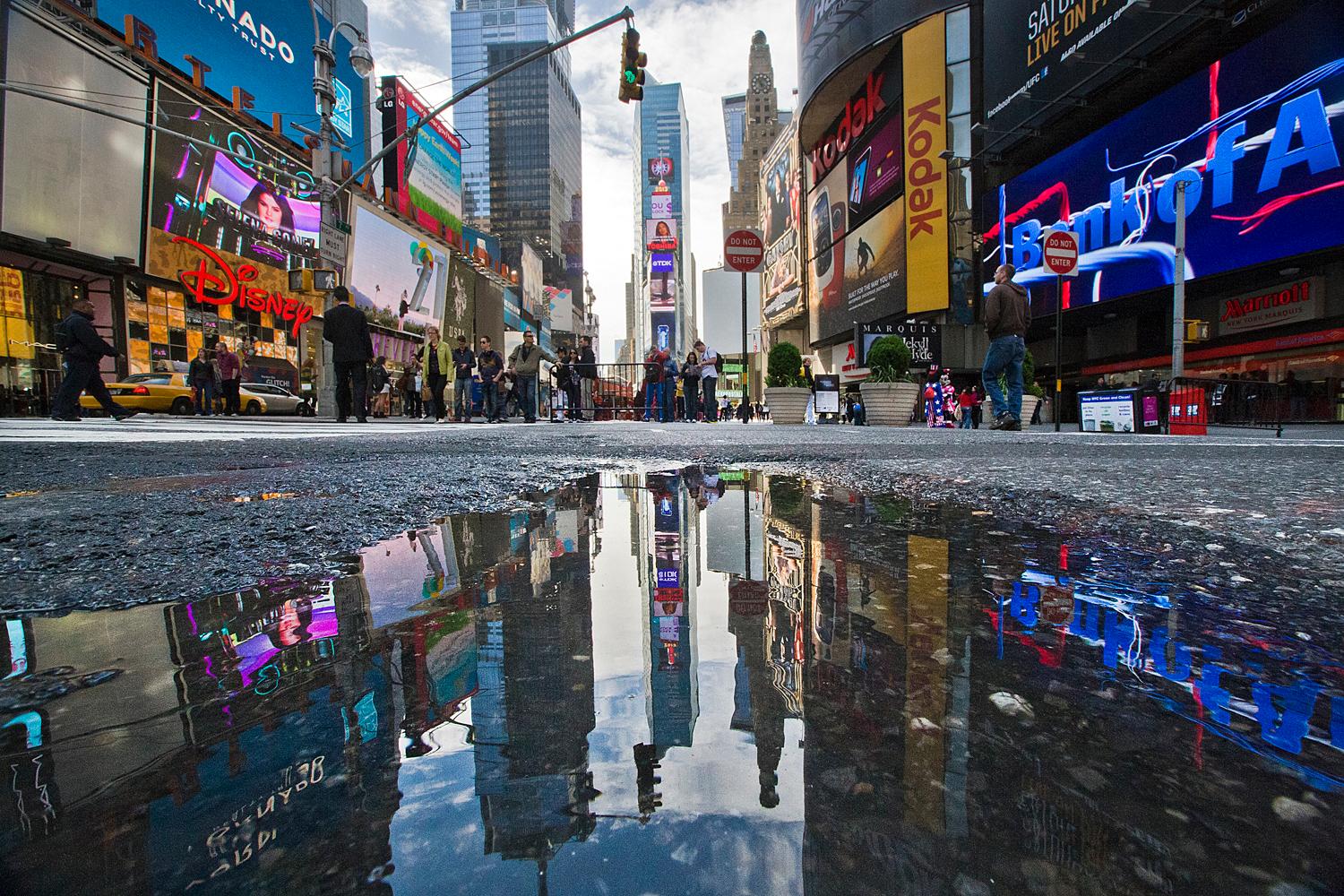 Vedno živahni Times Square na Manhattnu v New Yorku z oglasnimi panoji, vrvežem ljudi in gostim prometom.