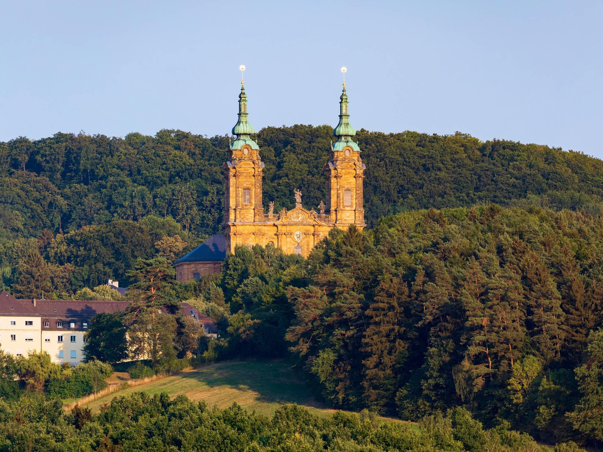 Baročna romarska cerkev Vierzehnheiligen na Bavarskem sredi bujnega zelenja.