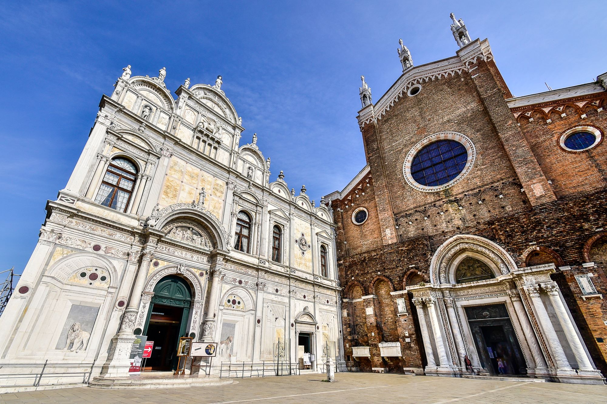 Pogled na fasadi bazilike San Zanipolo in Scuola Grande di San Marco na trgu svetega Janeza in Pavla v Benetkah.
