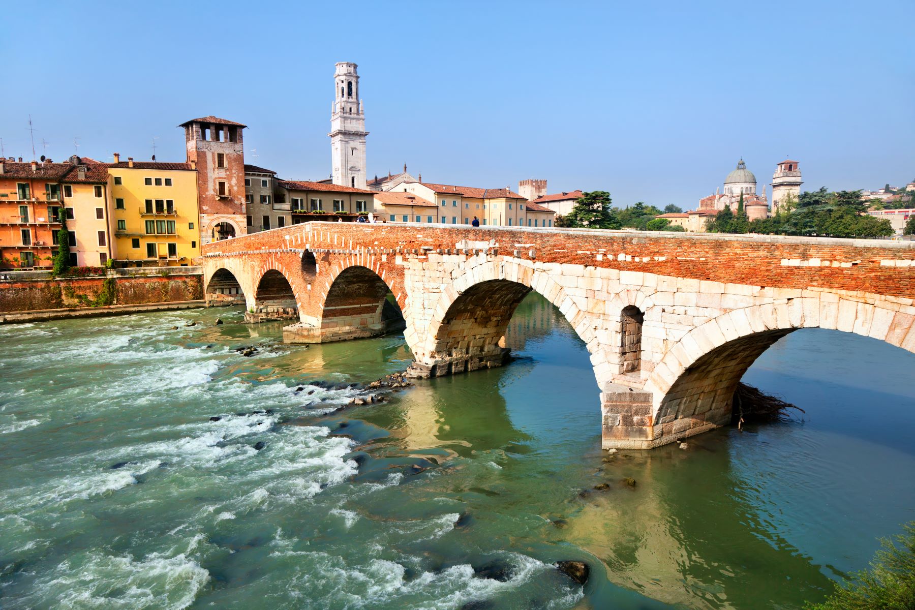 Most Ponte Pietra, ki se pne nad reko Adižo, in istoimenski stolp, ki predstavlja vhod v staro mestno jedro Verone.