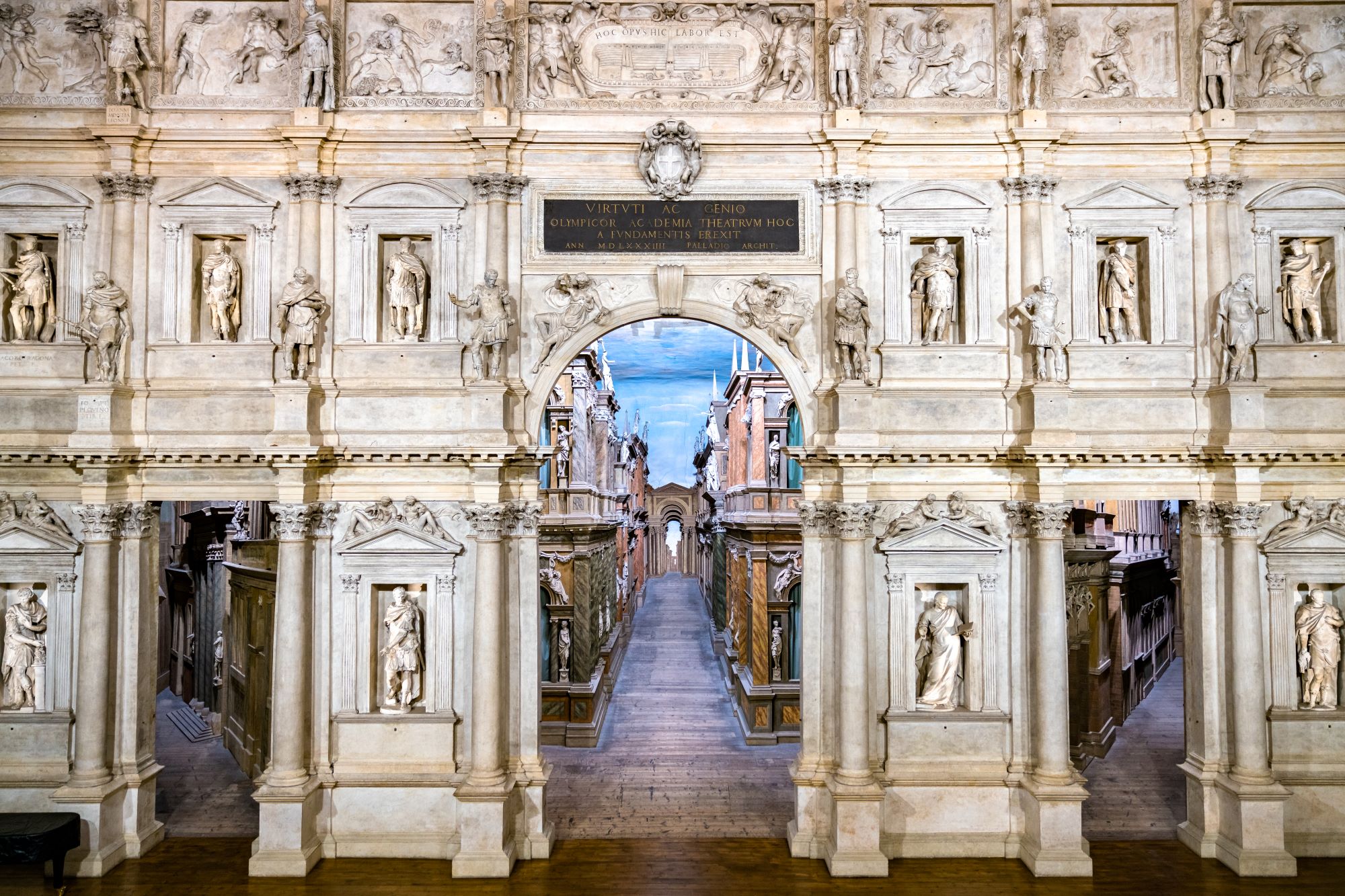 Dovršena odrska scena gledališča Teatro Olimpico v Vicenzi v Italiji s slavolokom v sredini, ki je znan kot porta regia ali kraljevski lok.