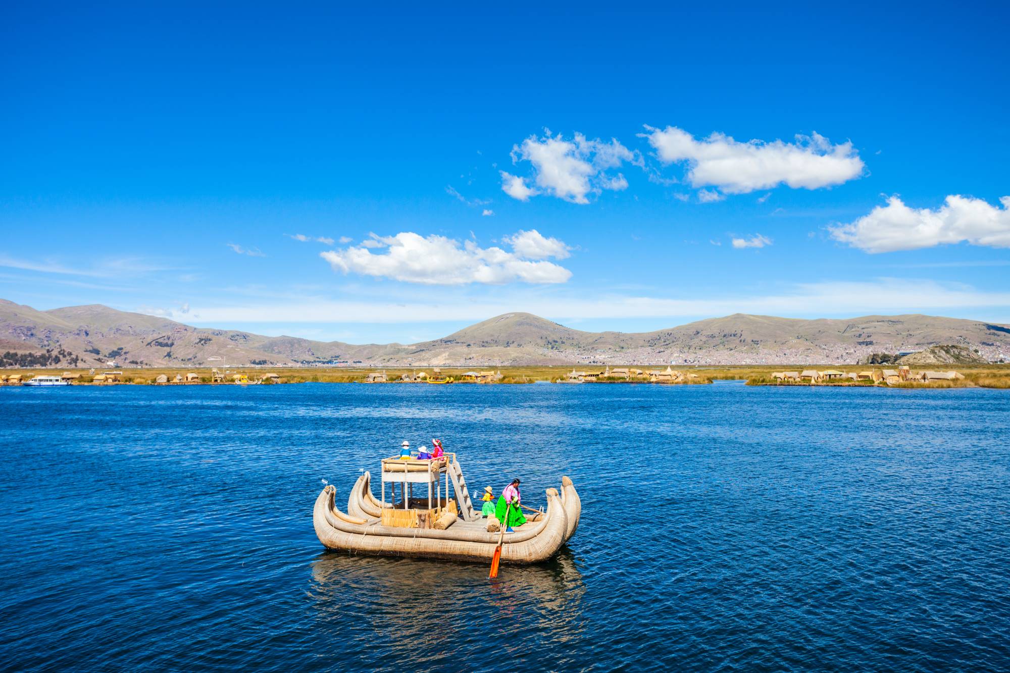 Plovba s tradicionalnim čolnom po jezeru Titicaca na perujsko-bolivijski visoki planoti Altiplano v perujskih Andih.