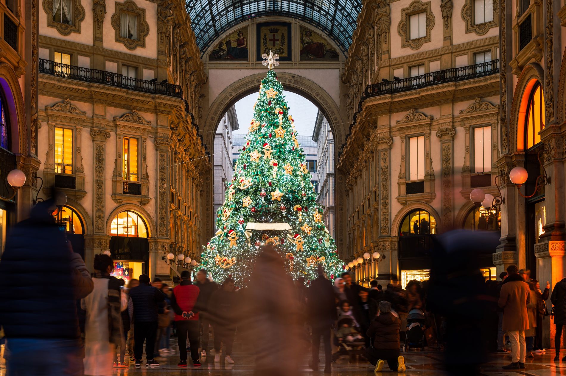 Nakupovalci se v adventnem času sprehajajo po enem najstarejših nakupovalnih središč na svetu Galleria Vittorio Emanuele II. v središču Milana v Italiji, sredi katerega stoji okrašeno božično drevo.