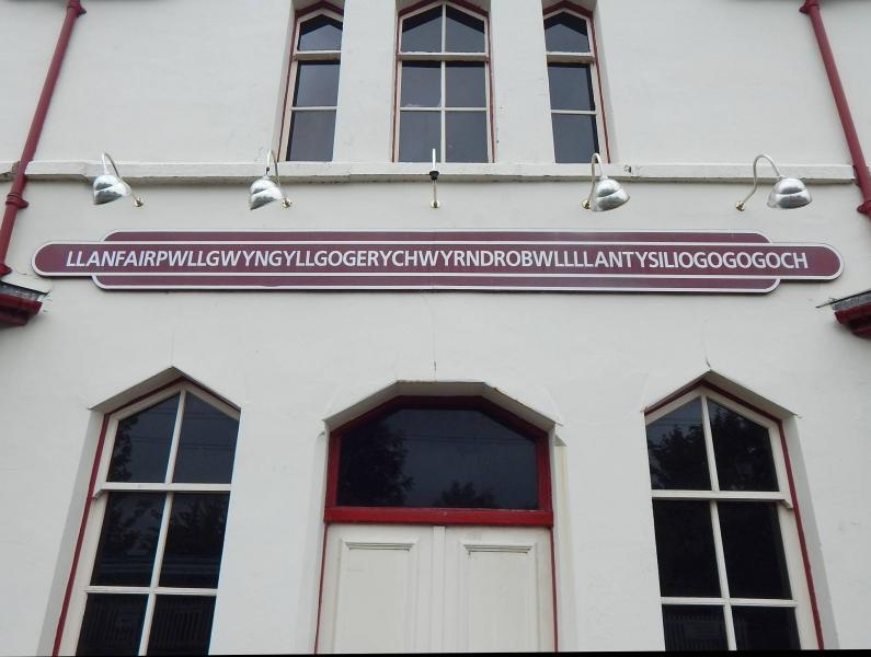 Napis mesta z najdaljšim imenom v Walesu Llanfairpwllgwyngyllgogerychwyrndrobwllllantysiliogogogoch na fasadi hiše.