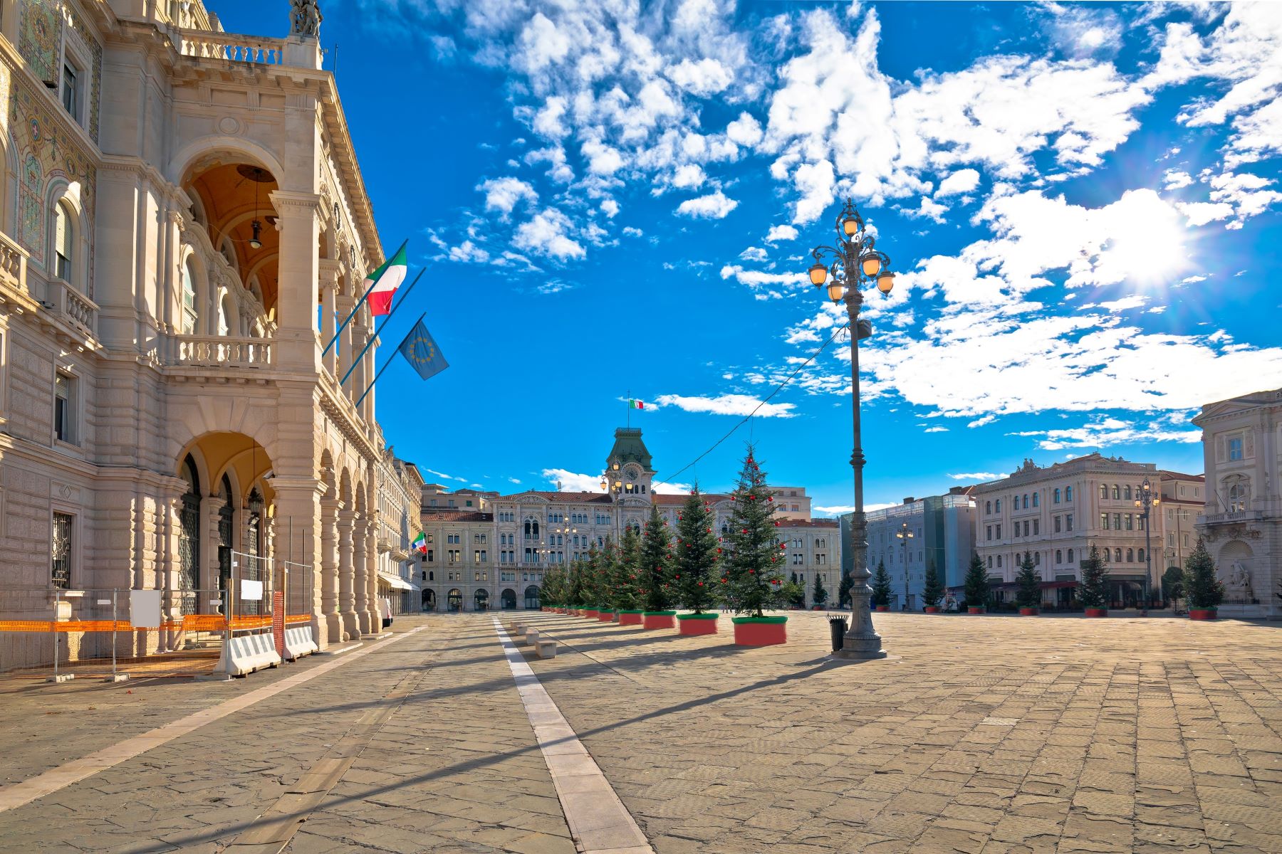 Praznično okrašen glavni trg v Trstu Piazza Unita z novoletnimi jelkami postavljenimi pred vladno palačo.