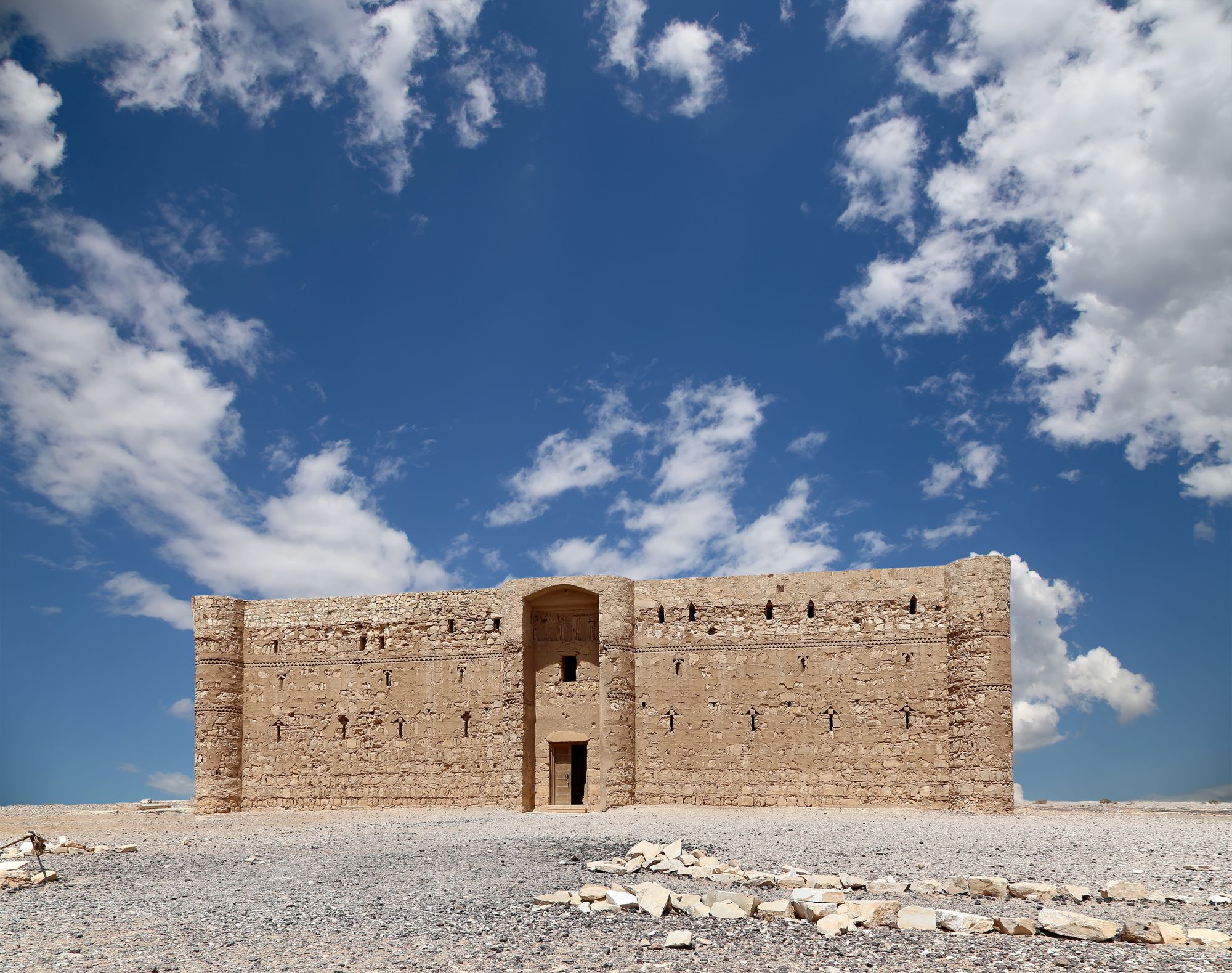 Modro nebo z belimi oblaki nad puščavskim gradom Kasr el Kharana na vzhodu Jordanije.
