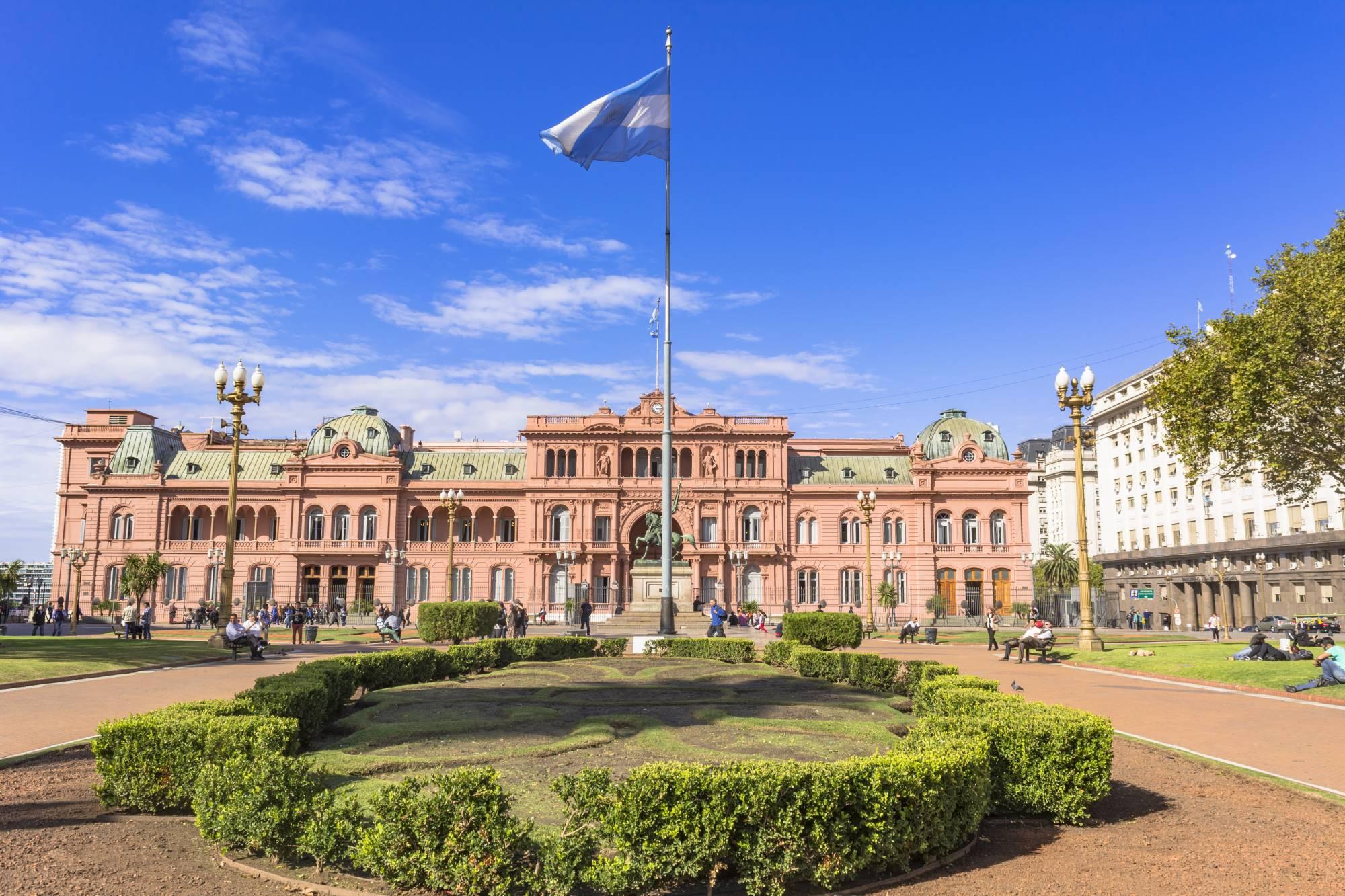 Legendarna vladna palača Casa Rosada v Buenos Airesu, pred katero plapola argentinska zastava.
