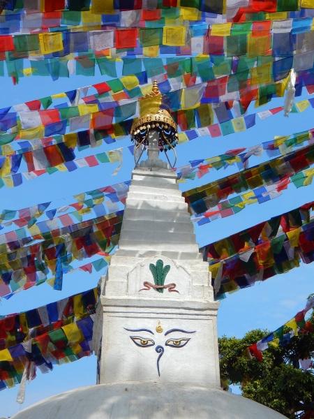 Vrh stupe v templju Swayambhunath v Katmandujski dolini v Nepalu z Budovimi očmi in molilnimi zastavicami.