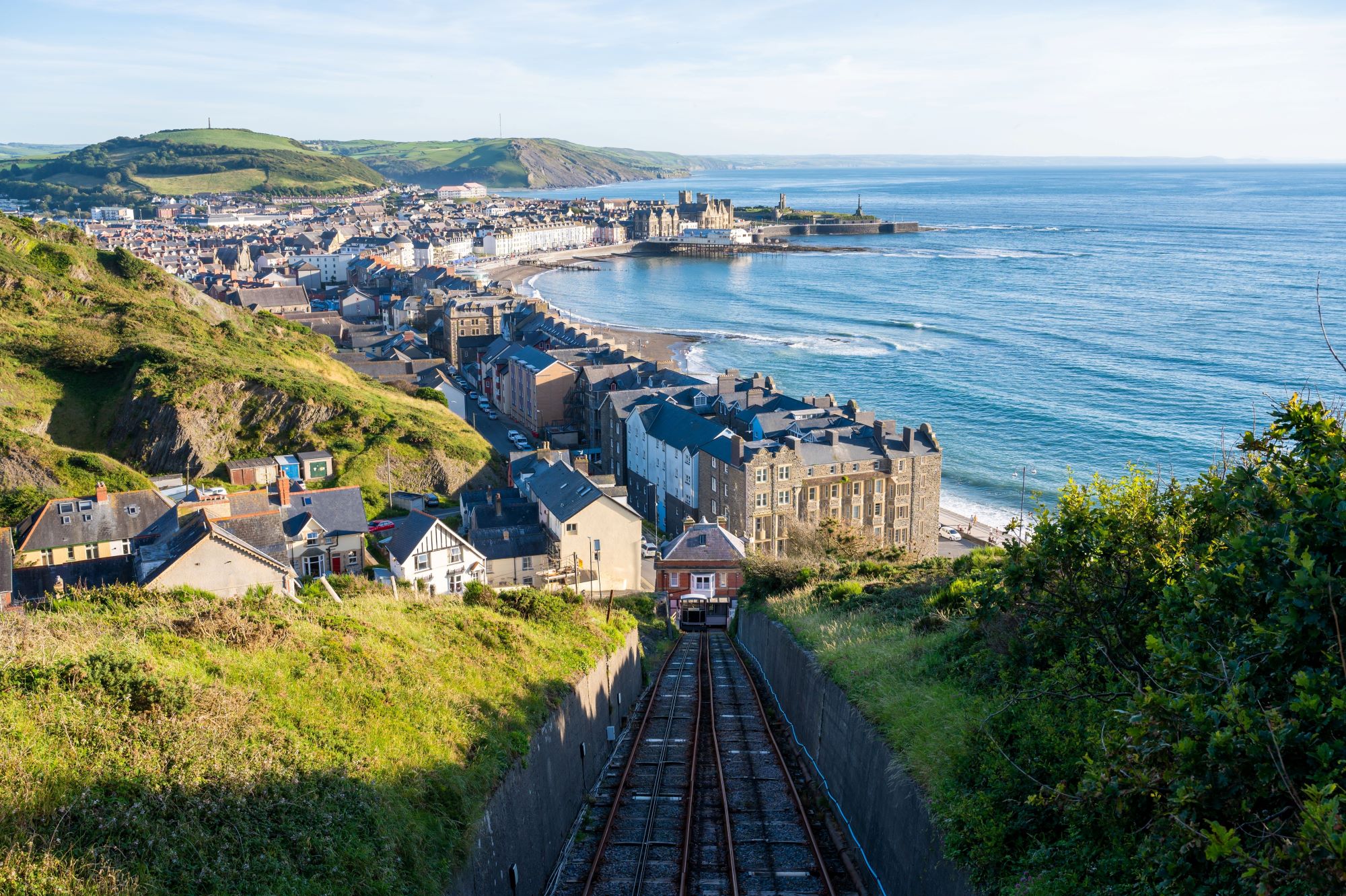 Pogled na Severno plažo in del letoviškega mesta Aberystwyth v Walesu z ozkotirno železnico.