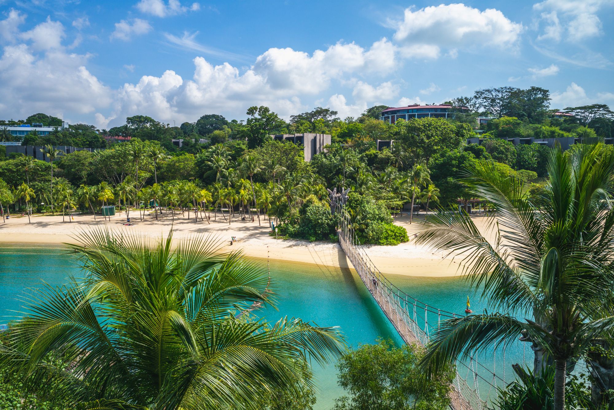 Pogled na plažo Palawan na otoku Sentosa, z visečim mostom čez morje.