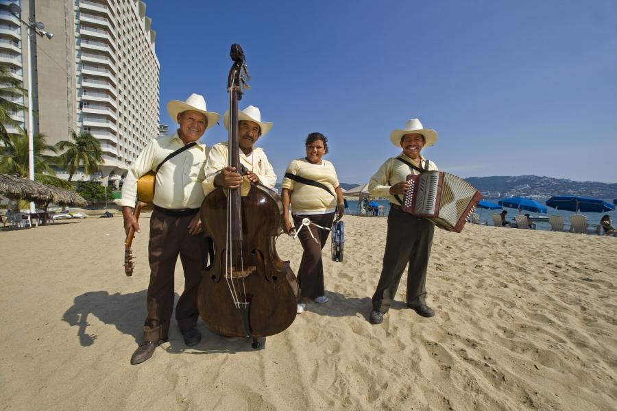 Mehiški glasbeniki Mariachi z glasbini na plaži ob karibskem morju.