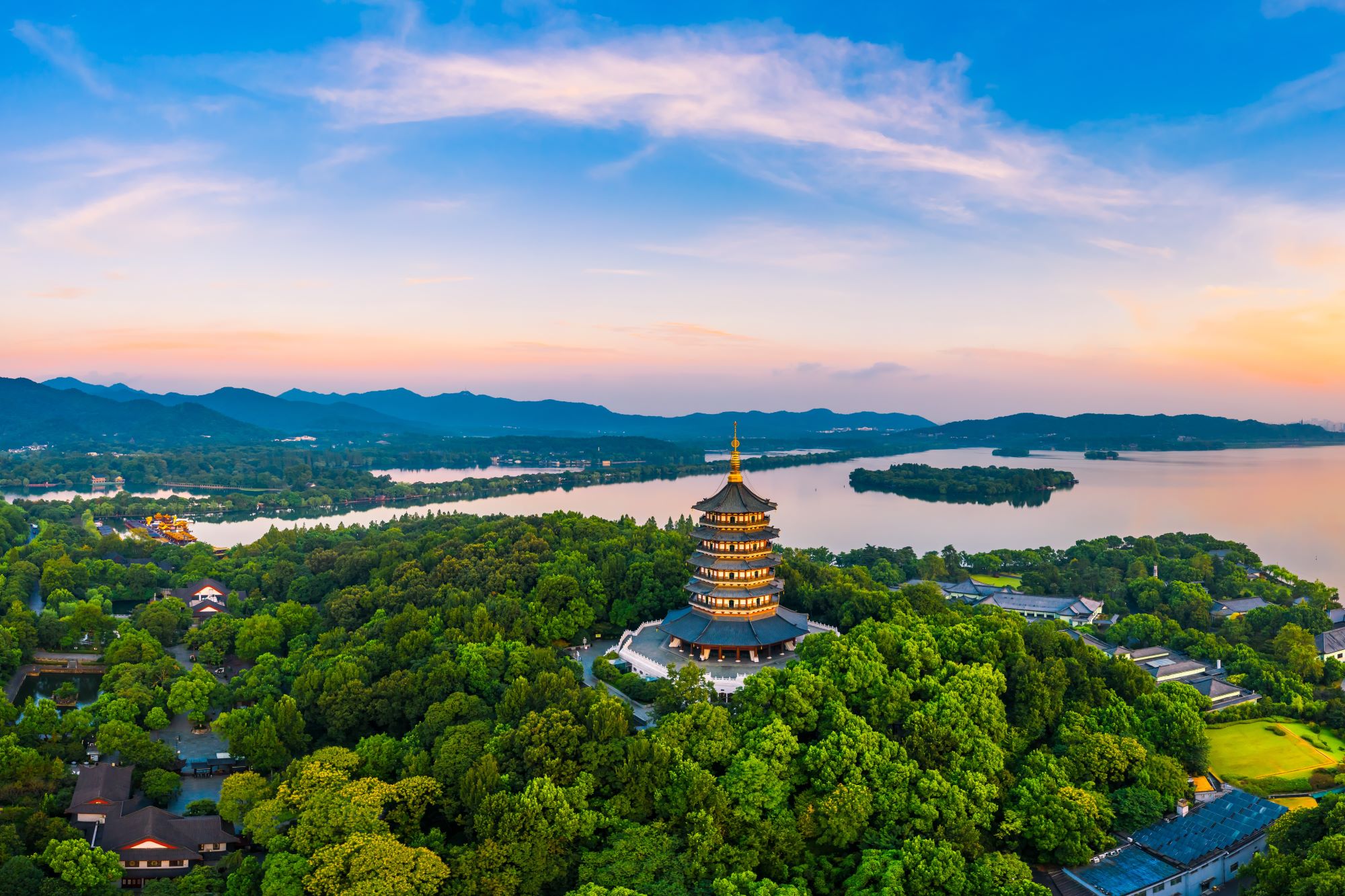 Panoramski pogled na Zahodno jezero v mestu Hangzhou na Kitajskem v sončnem zahodu in pagoda Bele kače.