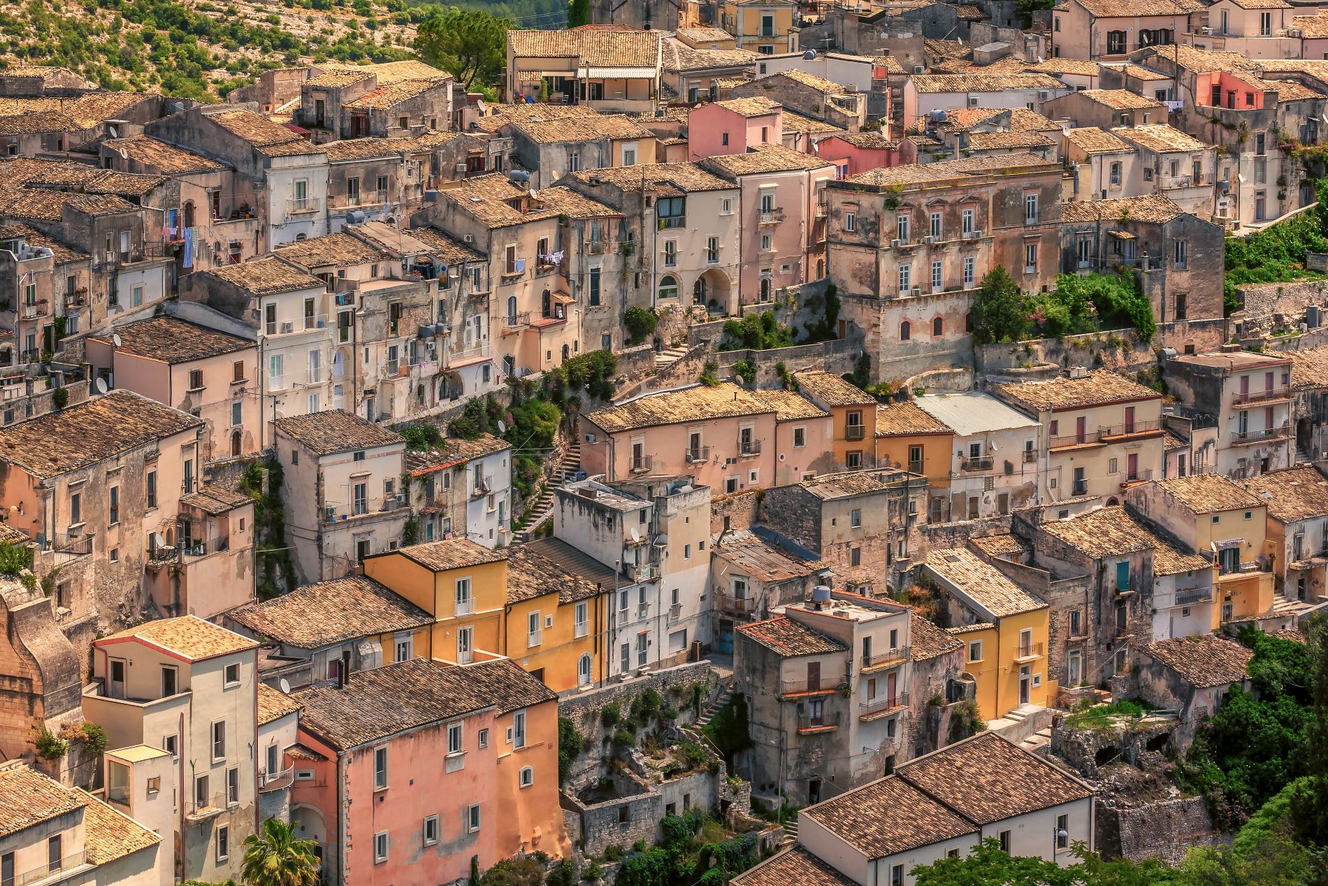 Pogled na mesto Ragusa na Siciliji z ozkimi zavitimi ulicami in starimi tesno skupaj zgrajenimi hišami.