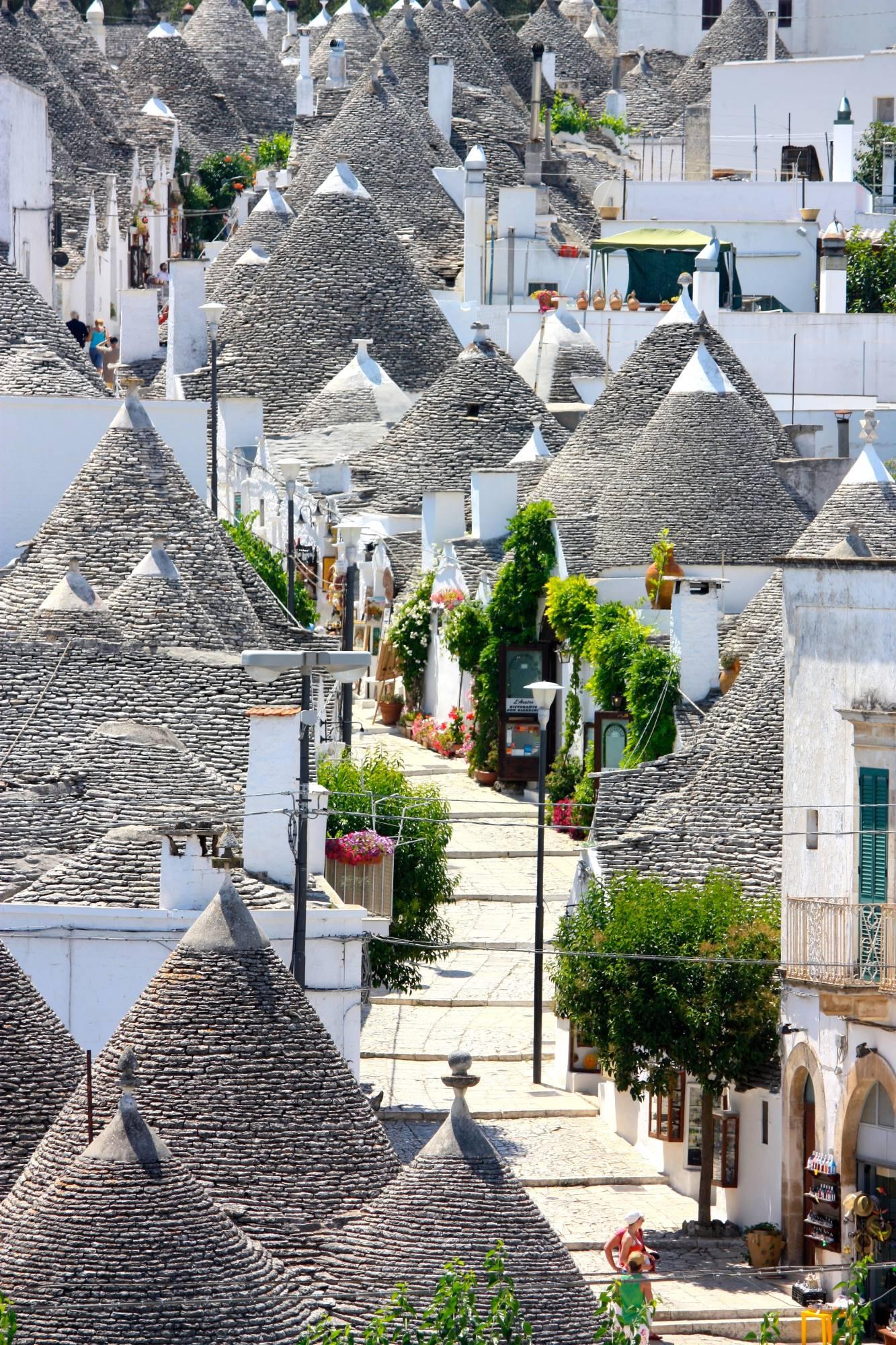 Pogled na pravljično vasico Alberobello z nenavadnimi stavbami s stožčastimi strehami.