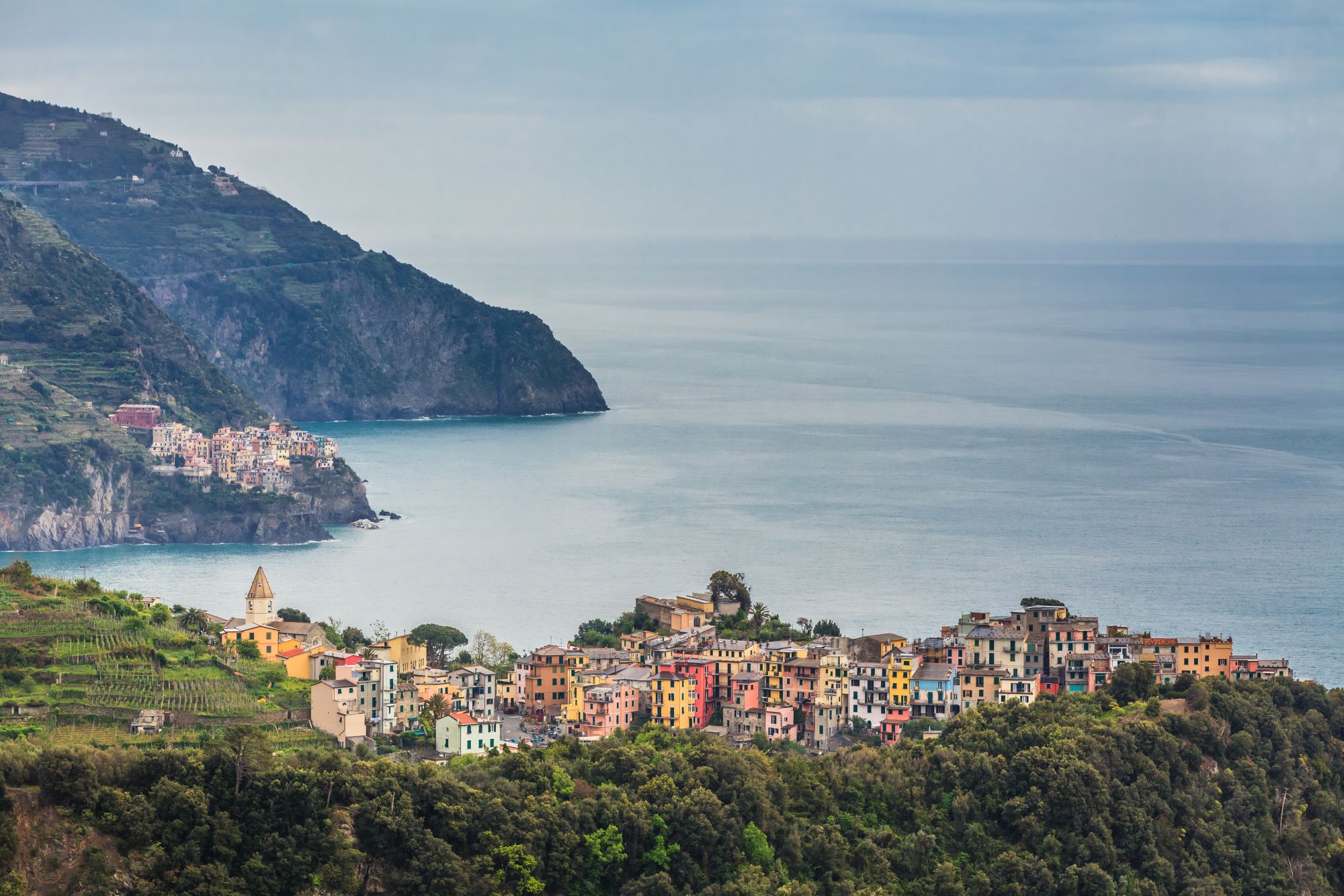 Pogled na ligurijsko obalo in eno od petih vasic Cinque Terre Corniglia, zgrajeno na vzpetini nad morjem.