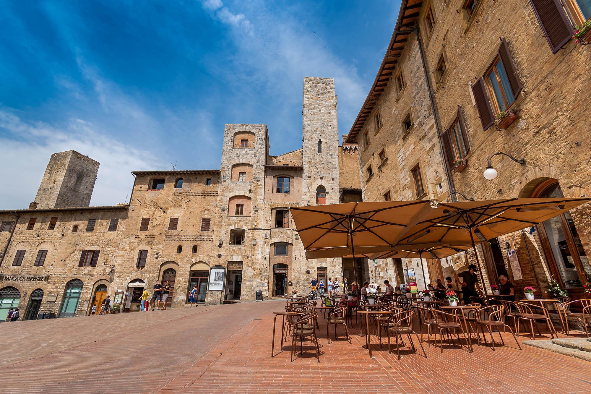 Piazza della Cisterna v središču San Gimignana, ki jo obdajajo hiše z značilnimi srednjeveškimi stolpi.