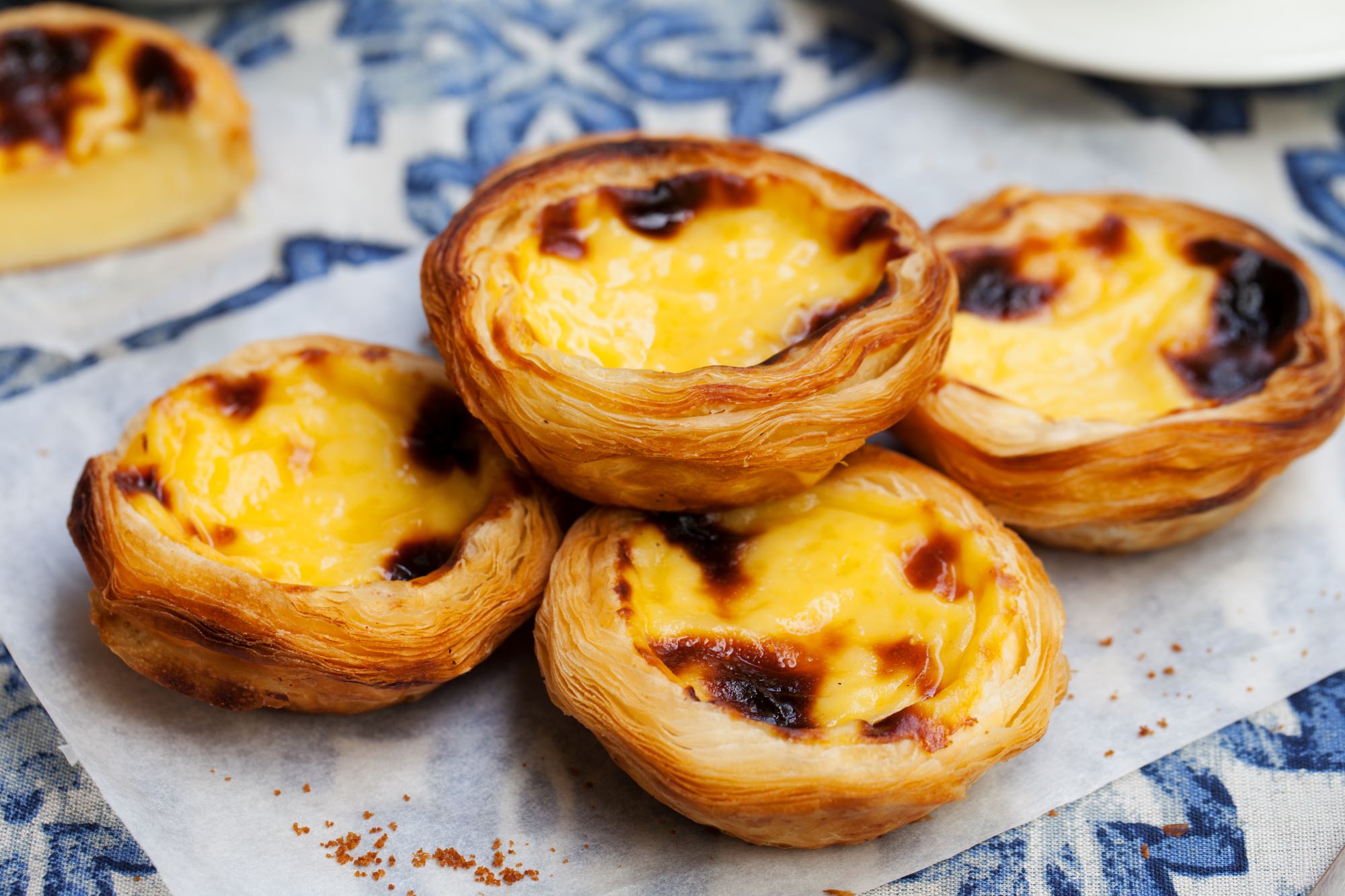 Postrežene portugalske sladice pastel de nata iz listnatega testa.